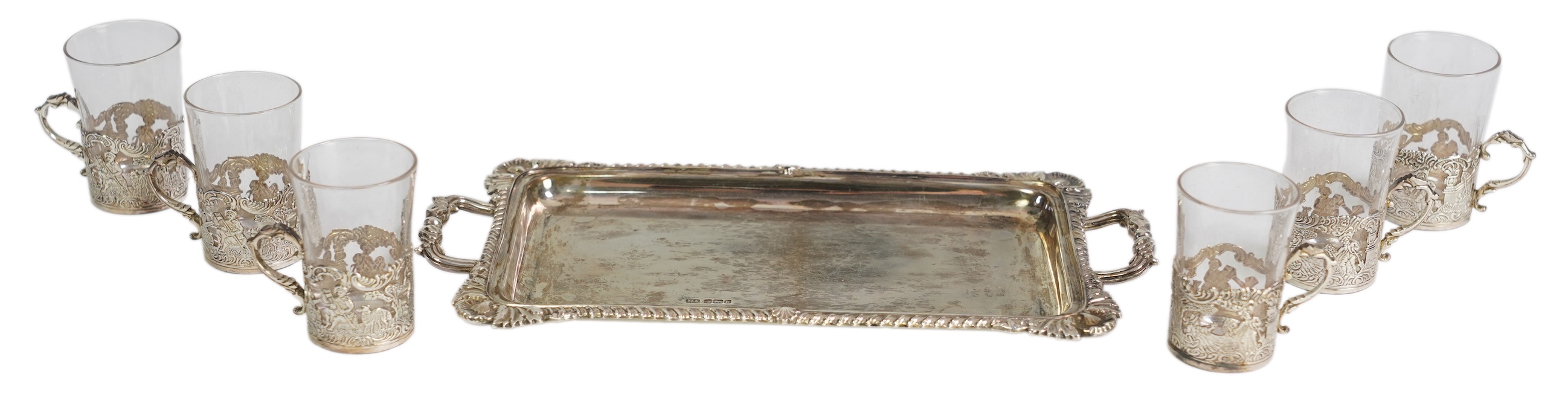 An Edwardian cased silver small two handled serving tray with six matching silver mounted glass liqueur tots, by Atkin Brothers